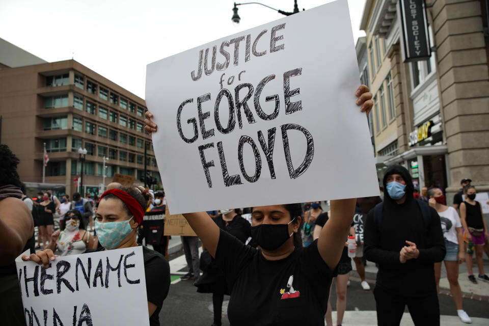 WASHINGTON, USA - MAY 29: A person holds a banner reading "Justice for George Floyd", as crowds gather to protest after the death of George Floyd in Washington D.C. United States on May 29, 2020. Floyd, 46, a black man, was arrested Monday after reportedly attempting to use a counterfeit $20 bill at a local store. Video footage on Facebook showed him handcuffed and cooperating. But police claimed he resisted arrest. A white officer kneeled on his neck, despite Floydâs repeated pleas of "I can't breathe." Former police officer Derek Chauvin was charged with third-degree murder and manslaughter, according to Hennepin County Prosecutor Michael Freeman. Minneapolis, Minnesota Mayor Jacob Frey said Friday he imposed a mandatory curfew because of ongoing protests regarding the death of George Floyd. (Photo by Yasin Ozturk/Anadolu Agency via Getty Images)