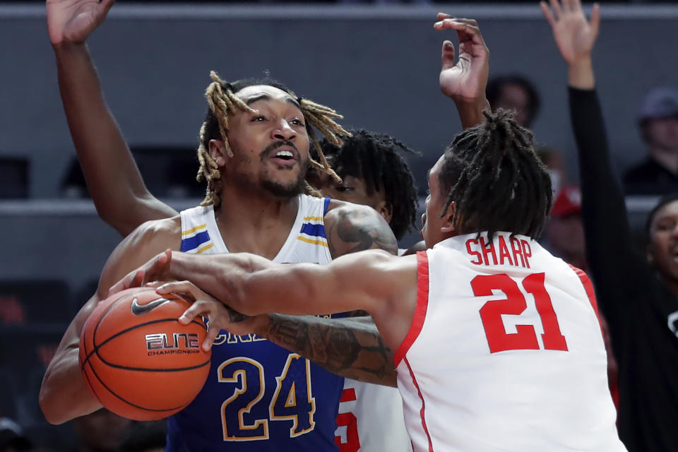 McNeese State forward Christian Shumate (24) has the ball knocked away by Houston guard Emanuel Sharp (21) during the first half of an NCAA college basketball game Wednesday, Dec. 21, 2022, in Houston. (AP Photo/Michael Wyke)