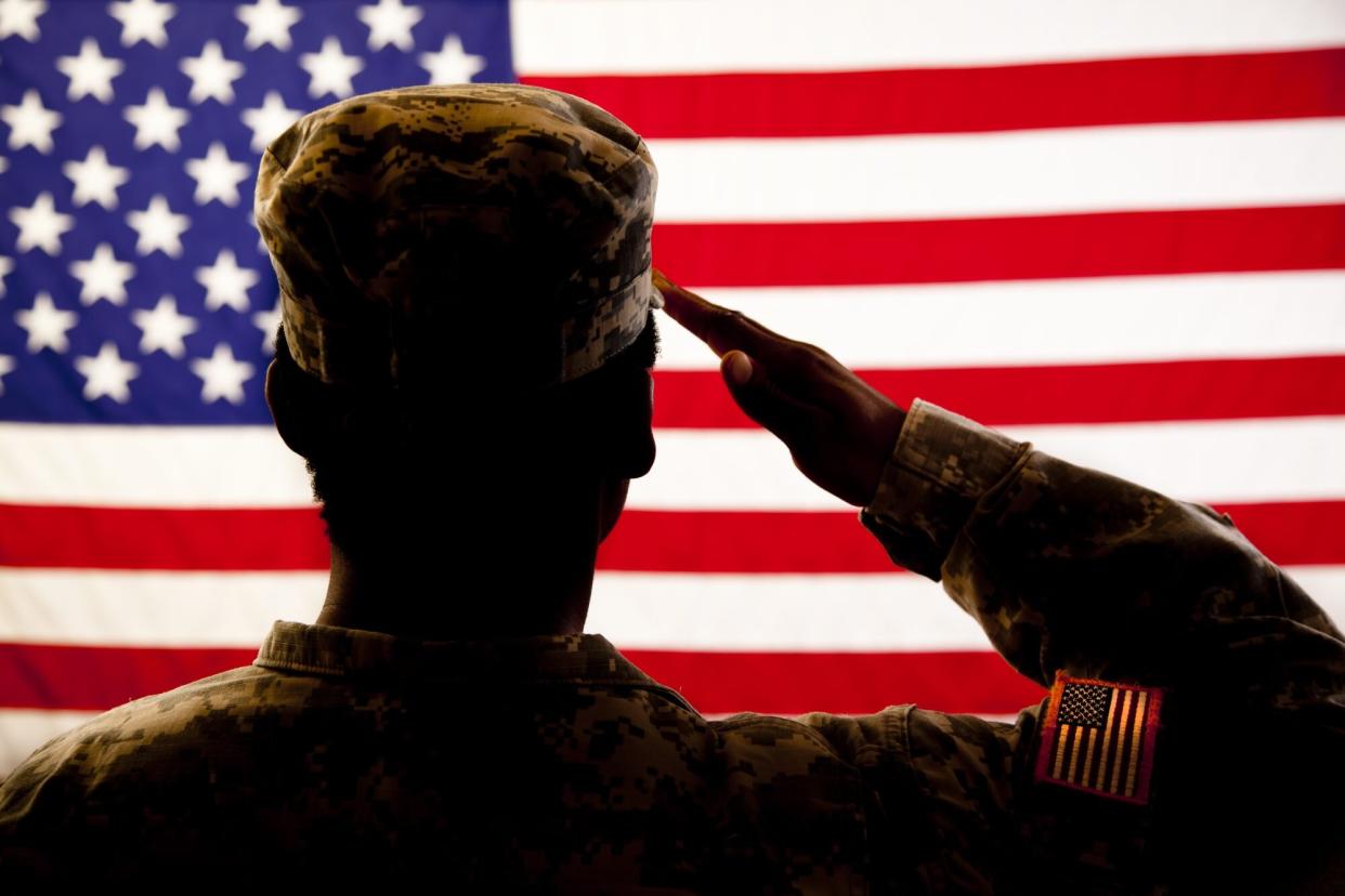 silhouette of solider saluting American flag