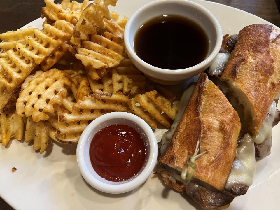 The French dip includes a choice of side, such as the waffle fries, at Tavern Grill at Jordan Creek Town Center.