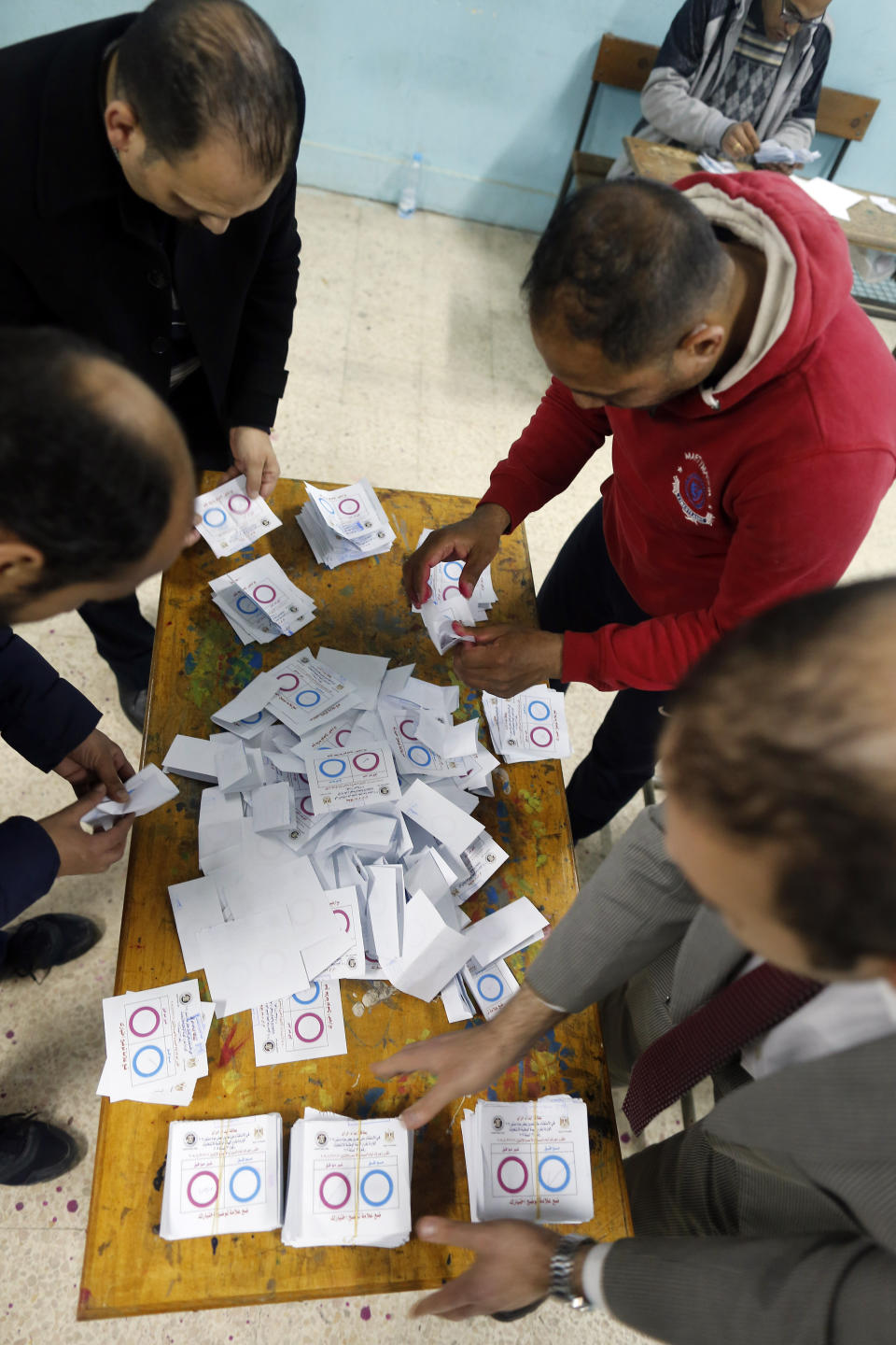 Election workers count ballots at the end of three-day vote of the referendum on constitutional amendments at polling station in Cairo, Egypt, Monday, April 22, 2019. Egyptians are voting on constitutional amendments that would allow el-Sissi to stay in power until 2030.(AP Photo/Amr Nabil)