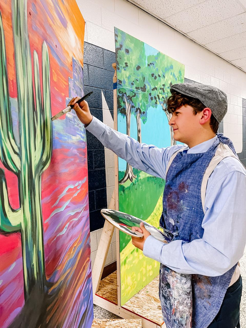 Turner Reed touches up one of the flats for the Halls Middle School production of "Disney’s Newsies Jr" on May 3, 2023. Reed plays Jack Kelly in the musical. When the newspaper publishers raise the prices of the newspapers at the cost of the newsboys, Jack Kelly rallies the newsies across New York City to strike against the unfair situation.