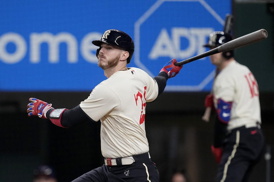 Texas Rangers' Jonah Heim follows through on a run-scoring single in the fourth inning of a baseball game against the Seattle Mariners, Saturday, Sept. 23, 2023, in Arlington, Texas. Adolis Garcia scored on the hit. (AP Photo/Tony Gutierrez)