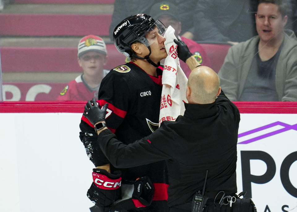 Ottawa Senators left wing Parker Kelly is helped off the ice after taking a puck in the face while taking on the Chicago Blackhawks in the second period of an NHL hockey game in Ottawa, Ontario, on Thursday, March 28, 2024. (Sean Kilpatrick/The Canadian Press via AP)