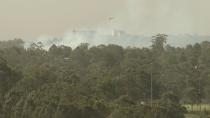 A helicopter flies over a bushfires in South Turramurra