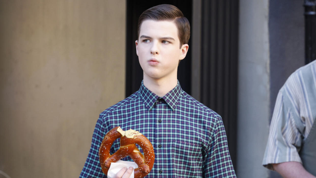  Sheldon holding a big pretzel in Young Sheldon. 