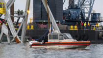In this photo provided by the U.S. Coast Guard, a Coast Guard Station Crisfield 29-foot response boat-small crew observes as demolition crews cut the top portion of the north side of the collapsed Francis Scott Key Bridge into smaller sections for safe removal by crane in the Patapsco River, in Baltimore, Saturday, March 30, 2024. Salvage teams used an exothermic cutting torch to systematically separate sections of the steel bridge, which will be taken to a disposal site. (Petty Officer 3rd Class Kimberly Reaves/U.S. Coast Guard via AP)