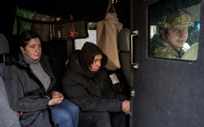 Svitlana Mazurina and her son Oleksii are evacuated from Avdiivka by Ukrainian police. &quot;It's hard when you've lived in this town from birth,&quot; Svitlana said. &quot;Now I'm leaving ... I dont know where or what to start with.&quot; - Evgeniy Maloletka/AP