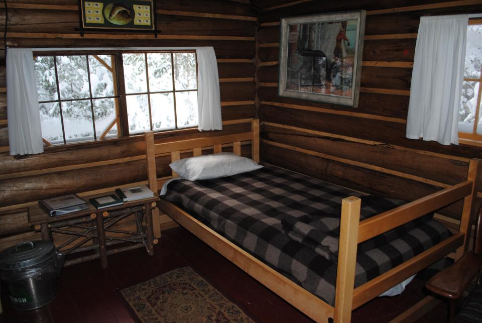 This December 2012 photo shows the interior of a rustic cabin at the Appalachian Mountain Club’s Little Lyford Lodge and Cabins, a backcountry wilderness lodge near Greenville, Maine. The cabin has no electricity, is heated by a wood stove and lit by gas lamp. In winter, visitors can reach the lodges and cabins only by cross-country skiing in. (AP Photo/Lynn Dombek)