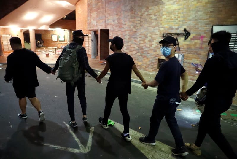 Anti-government protesters leave the campus of the Polytechnic University (PolyU) to give themselves up to the police in Hong Kong