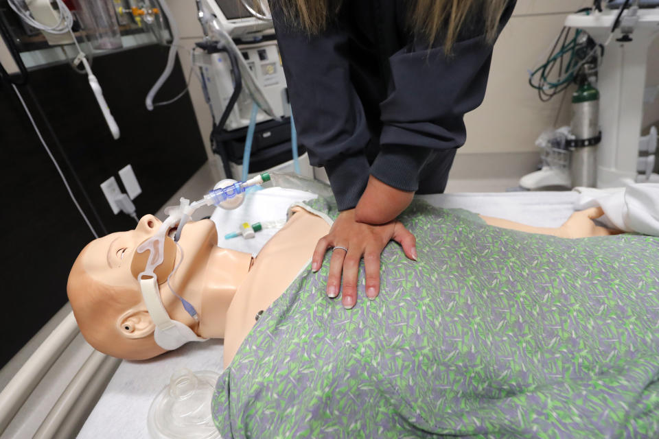 REMOVES REFERENCE OF AMPUTEE - Respiratory therapist Savannah Stuard, who was born without a left forearm, demonstrates her chest compression technique for treating COVID-19 patients, at Ochsner Medical Center in New Orleans, Tuesday, July 28, 2020. The Associated Press was not allowed into the hospital's COVID-19 intensive care unit. (AP Photo/Gerald Herbert)