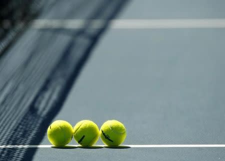 Tennis balls sit on the court before a match at the Australian Open tennis tournament in Melbourne January 23, 2008. REUTERS/Petar Kujundzic/Files