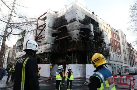 Firefighters look at the damaged caused by a fire at a construction site in central London, Britain, February 17, 2018. REUTERS/Simon Dawson