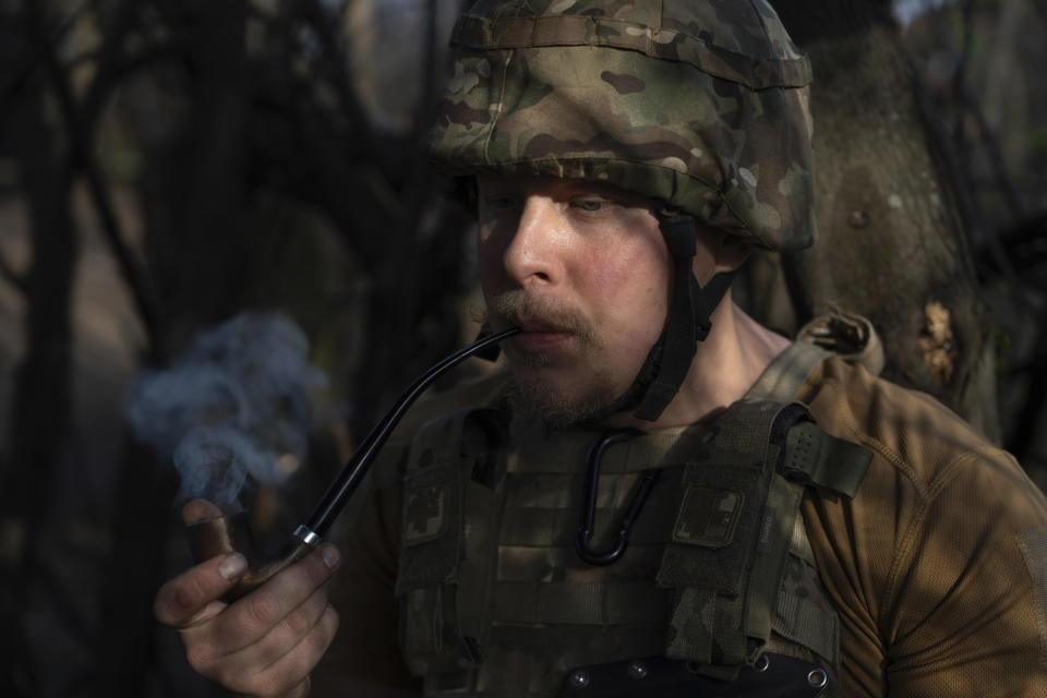 A Ukrainian serviceman from Azov brigade known by call sign Kiss, smokes a pipe on the frontline in Kreminna direction, Donetsk region, Ukraine, Thursday, April 11, 2024. (AP Photo/Alex Babenko)
