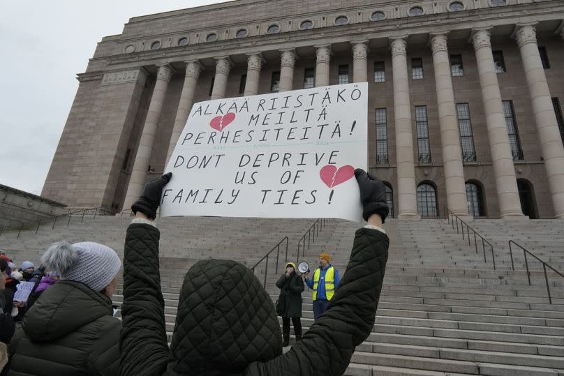 Люди, в основном этнические русские, собираются перед парламентом Финляндии в знак протеста против закрытия пунктов пропуска на границе с Россией в Хельсинки, 18 ноября 2023 года.