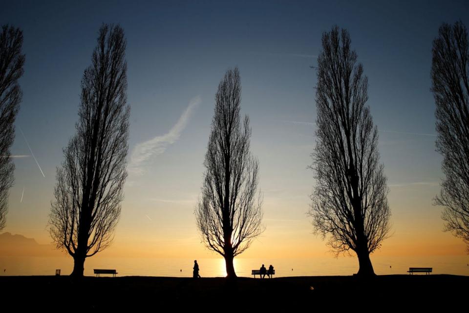 <p>Im schweizerischen Lutry, nahe des Genfersees, genießen Menschen auf einer Parkbank einen milden Herbstabend. (Bild: Denis Balibouse/Reuters) </p>