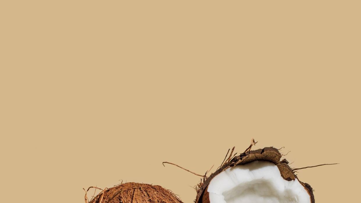 ripe coconuts on beige background creative summer concept half of coconut in minimal flat lay style top view, copy space