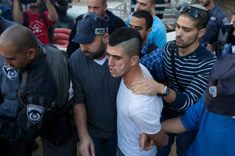 Israeli security forces arrest a Palestinian man (2-R) on suspicion of stabbing and wounding a woman in north Jerusalem on November 29, 2015