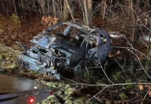 A state police trooper broke the window of a burning car to rescue a woman who crashed into a tree on Route 101 in Epping on Tuesday night.