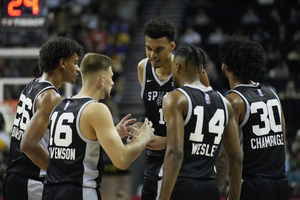 San Antonio Spurs' Victor Wembanyama, center, speaks with teammates during the first half of an NBA summer league basketball game against the Portland Trail Blazers, Sunday, July 9, 2023, in Las Vegas. (AP Photo/John Locher)