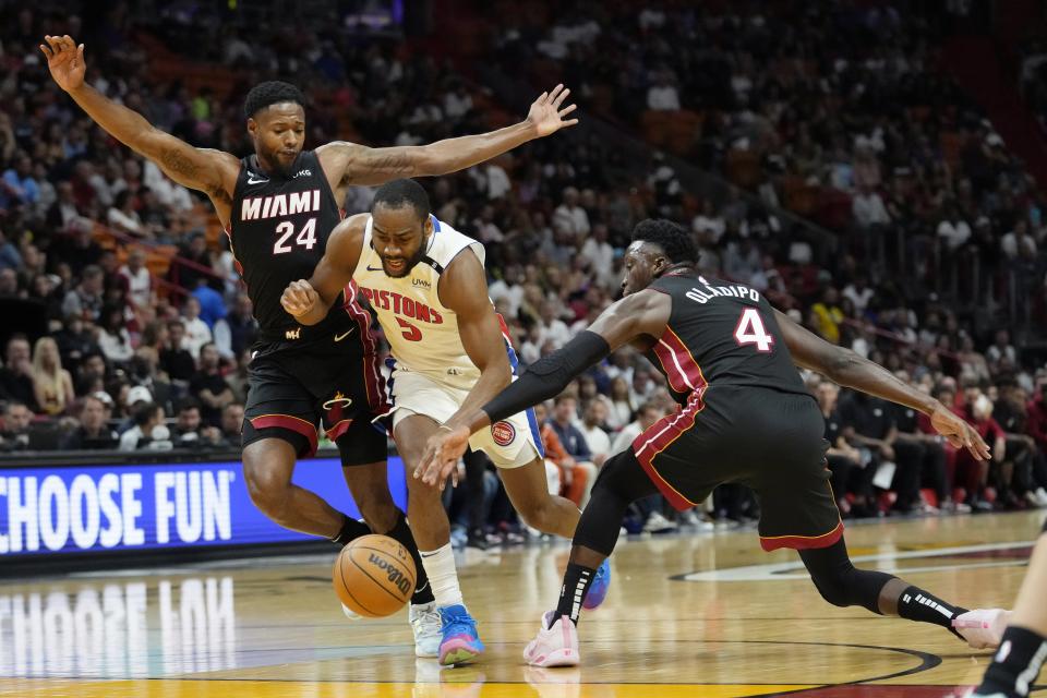 Pistons guard Alec Burks is fouled by Heat forward Haywood Highsmith, left, as guard Victor Oladipo defends during the first half on Tuesday, Dec. 6, 2022, in Miami.