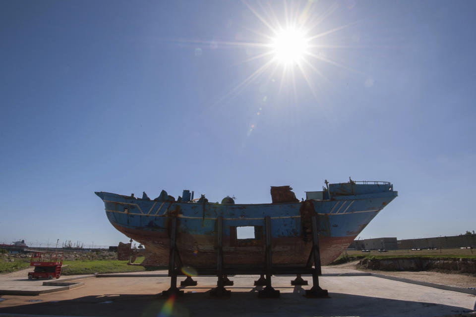FILE - In this Oct. 8, 2016 file photo, the hull of a fishing boat that capsized off the coast of Libya sits outside, at the NATO base in the Sicilian town of Melili, Italy. The story of the fishing boat known as the "peschereccio" and its passengers reflects how migrants can simply vanish worldwide, sometimes without a trace. (AP Photo/Salvatore Cavalli, File)