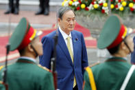 Japanese Prime Minister Yoshihide Suga reviews an honor guard at the Presidential Palace in Hanoi, Vietnam Monday, Oct. 19, 2020. Suga is on an official visit to Vietnam. (AP Photo/Minh Hoang, Pool)