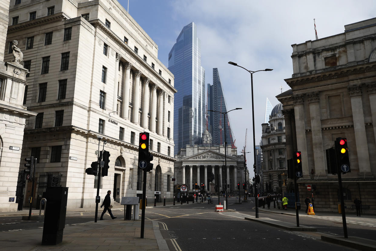 LONDON, ENGLAND - MARCH 01: A pedestrian crosses the street in view of the City of London skyline on March 1, 2021 in London, England. As the government prepares to present the 2021 Budget to parliament on Wednesday, political factions within the ruling Conservative party and the opposition are weighing in on how they think the government can best shape its tax and spending plans to recover from the economic devastation of Covid-19. (Photo by Hollie Adams/Getty Images)