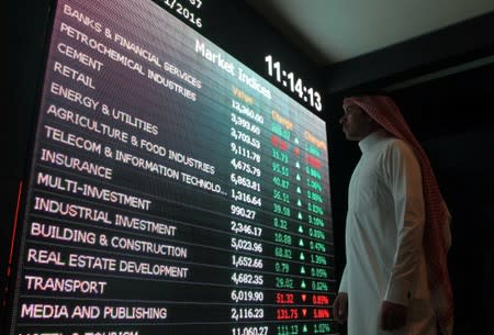 FILE PHOTO: An investor monitors a screen displaying stock information at the Saudi Stock Exchange (Tadawul) in Riyadh