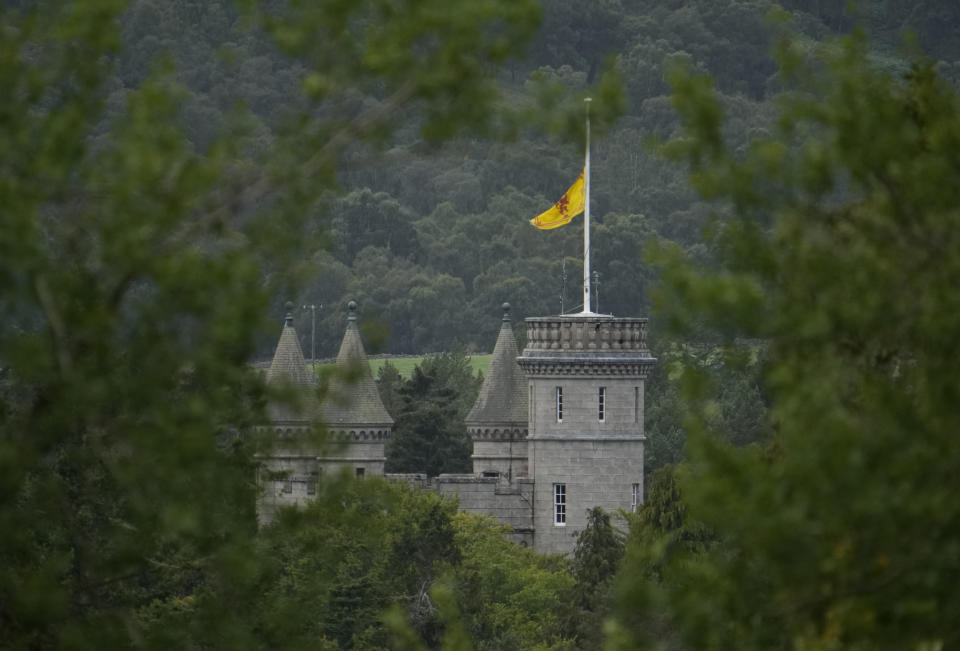 A flag flaps in the wind at half staff on Balmoral Castle in Aberdeenshire, Scotland, Friday, Sept. 9, 2022. Queen Elizabeth II, Britain's longest-reigning monarch and a rock of stability across much of a turbulent century, died Thursday after 70 years on the throne. She was 96. (AP Photo/Alastair Grant)