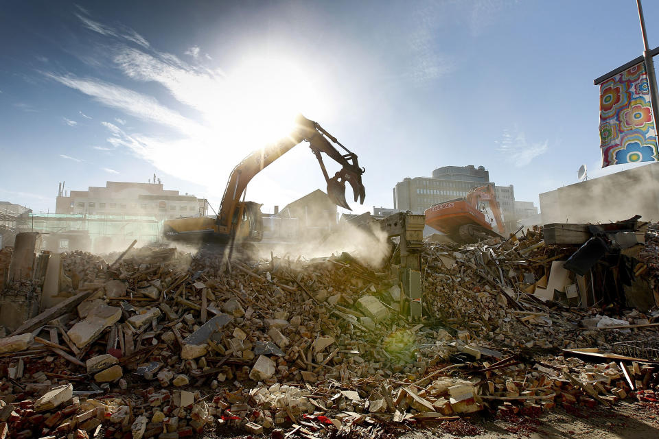 FILE- In this photo taken Friday, July 8, 2011, an excavator works on clearing rubble following the Feb. 2011, quake, in downtown Christchurch, New Zealand. Despite its tranquility and beauty, New Zealand city of Christchurch is painfully familiar with trauma and will need to use that experience to recover from terrorist attack. (AP Photo/Martin Hunter, File)