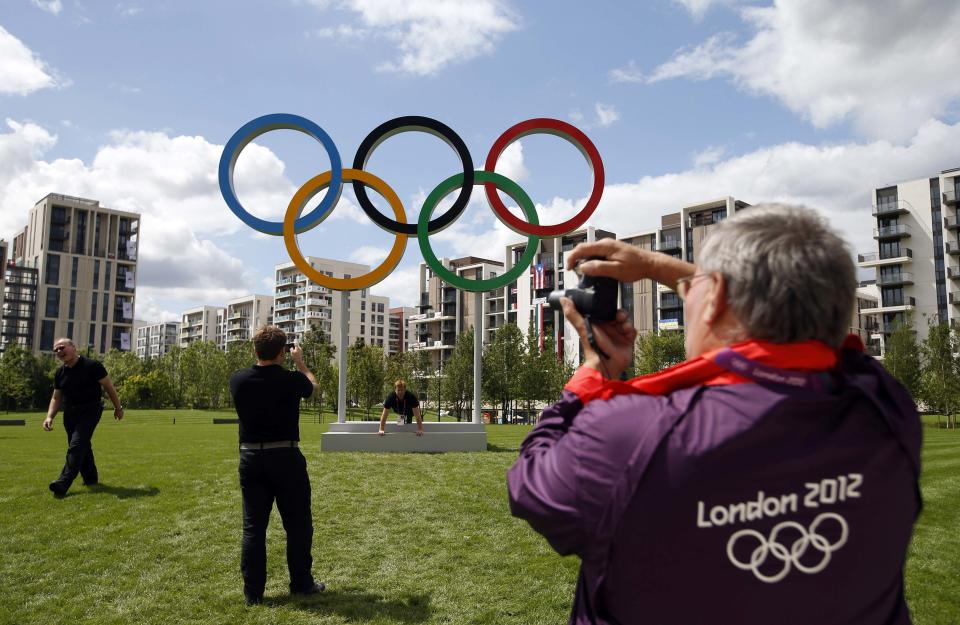 File photo of a volunteer taking a photograph of the Olympic rings at the Athletes' Village at the Olympic Park in London
