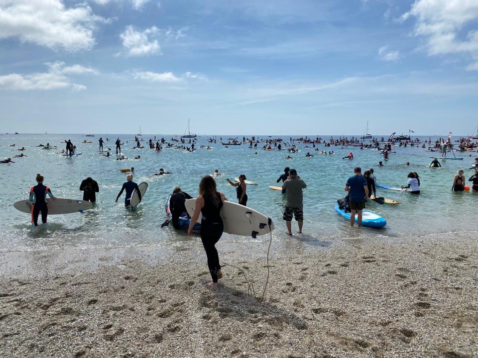 Waters sports enthusiasts takes to the sea at Gyllyngvase Beach, Cornwall, in England, to protest how oceans are impacted by climate change. Photo: June 12, 2021.
