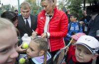 Russian tennis player Maria Sharapova signs autographs for children while visiting her first court in Riviera Park, Wednesday, Feb. 5, 2014, in Sochi, Russia, prior to the start of the 2014 Winter Olympics. (AP Photo/Pavel Golovkin)