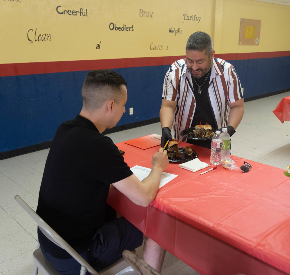 Friona City Manager places a cheeseburger before a judge Saturday at Friona's 17th annual Cheeseburger Festival.