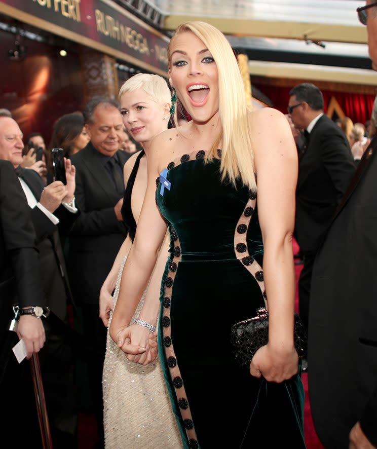 Michelle Williams and Busy Philipps held hands as they made their way into the Oscars ceremony. (Photo: Christopher Polk/Getty Images)