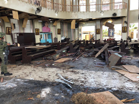 A Philippine Army member inspects the damage inside a church after a bombing attack in Jolo, Sulu province, Philippines January 27, 2019. Armed Forces Of The Philippines - Western Mindanao Command/Handout via REUTERS