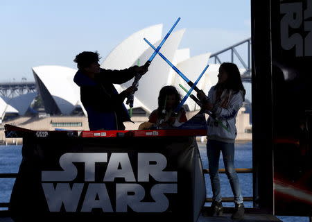 Caleb (L-R), Kayley and Annie Bratayley from the United States participate in a live internet unboxing event to reveal new light saber toys from the film "Star Wars - The Force Awakens" in Sydney, September 3, 2015. REUTERS/Jason Reed