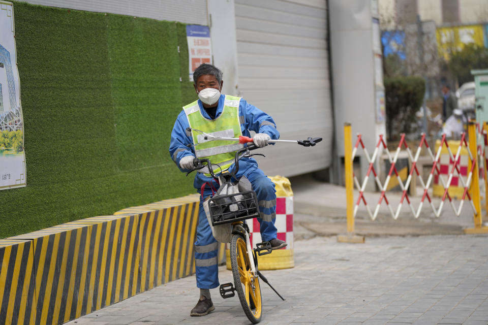 A municipal worker rides a bicycle on a street in Beijing, China, Thursday, March 21, 2024. China’s first generation of migrant workers played an integral role in the country's transformation from an impoverished nation to an economic powerhouse. Now, they're finding it hard to find work, both because they're older and the economy is slowing. (AP Photo/Tatan Syuflana)