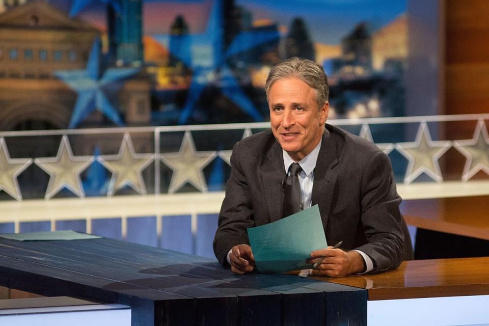 Jon Stewart sits at a desk in a still from 'The Daily Show with Jon Stewart'