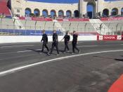 Crew members from Spire Motorsports walk the temporary auto racing track surface inside LA Coliseum ahead of a NASCAR exhibition race in Los Angeles, Friday, Feb. 4, 2022. NASCAR is hitting Los Angeles a week ahead of the Super Bowl, grabbing the spotlight with its wildest idea yet: The Clash, the unofficial season-opening, stock-car version of the Pro Bowl, will run at the iconic coliseum in a made-for-Fox Sports spectacular. (AP Photo/Jenna Fryer)