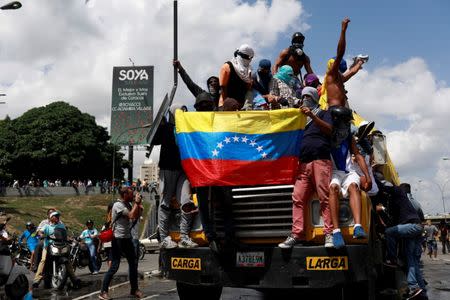 Demonstrators stand on top of a truck while blocking a highway during a rally against Venezuela's President Nicolas Maduro's Government in Caracas, Venezuela June 23, 2017. REUTERS/Marco Bello