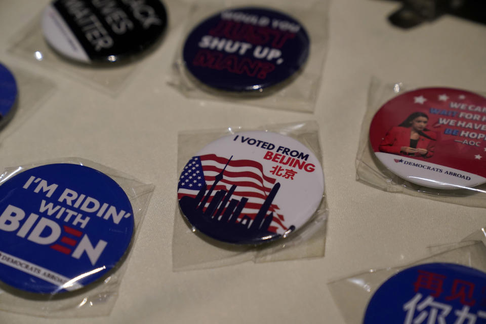 Badges are displayed at an election watch event held by Democrats Abroad at a restaurant in Beijing, China on Wednesday, Nov. 4, 2020. President Donald Trump and his Democratic challenger, Joe Biden, are in a tight battle for the White House. (AP Photo/Ng Han Guan)