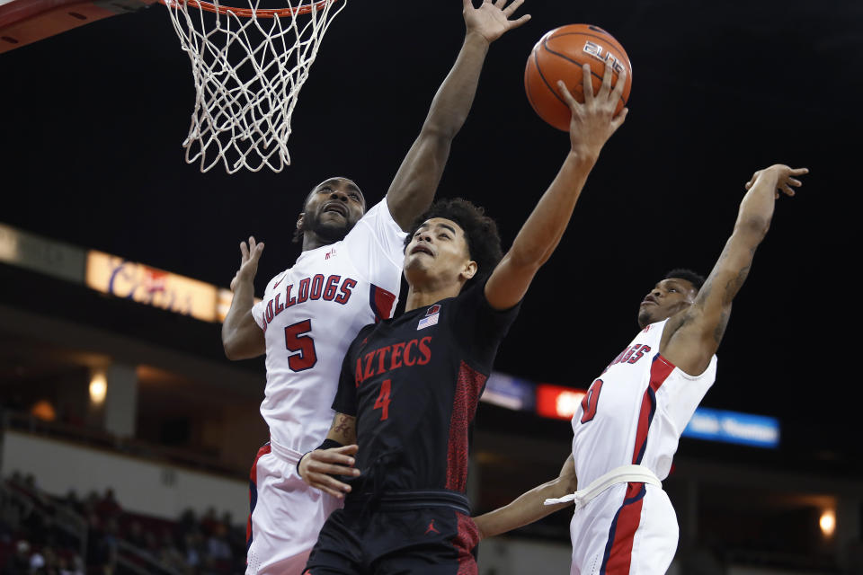 San Diego State's Trey Pulliam goes in for a layup against Fresno State's Jordan Campbell, left, and New Williams, right, during the first half of an NCAA college basketball game in Fresno, Calif., Tuesday Jan. 14, 2020. (AP Photo/Gary Trey Pulliam