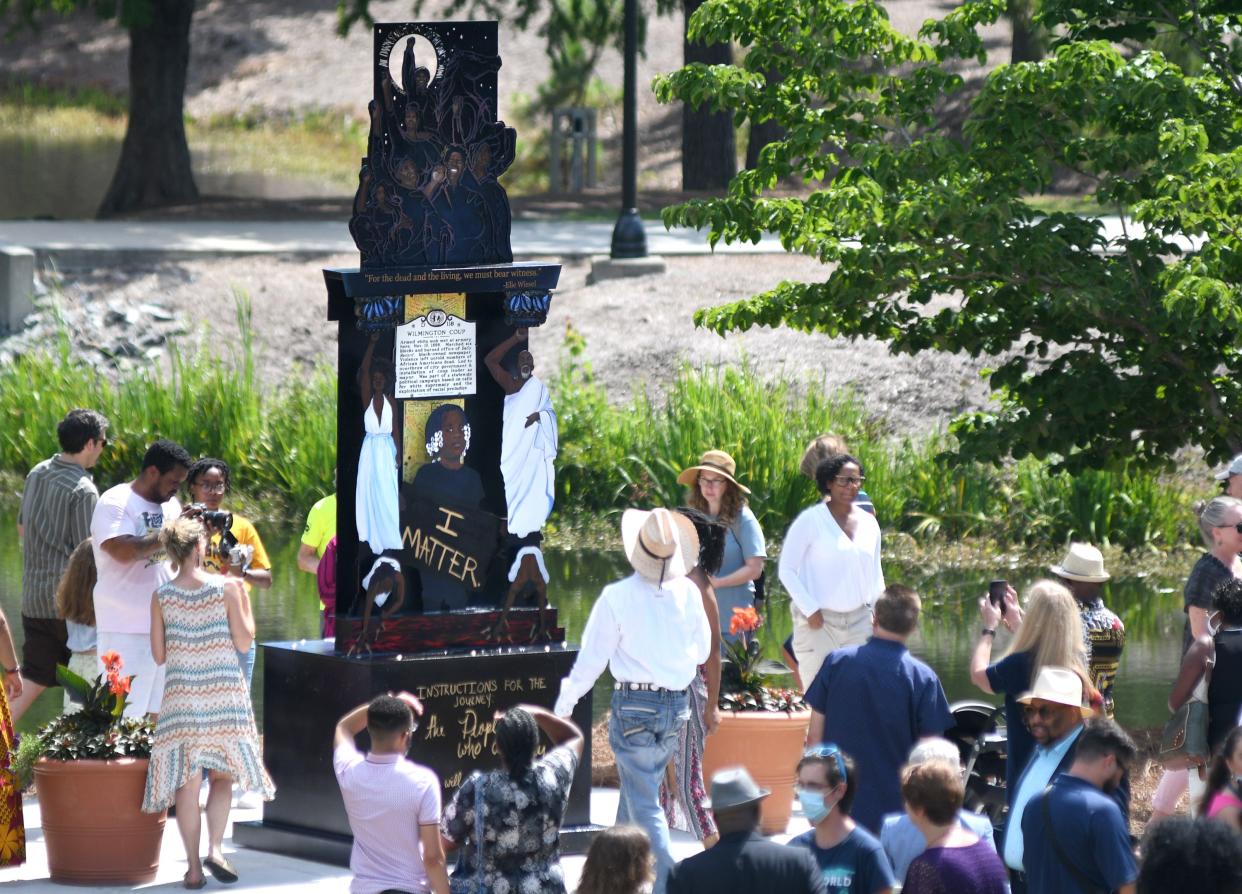 People look at "Because It's Time" shortly after the piece was unveiled following a ceremony at the UNCW Amphitheater in 2021.