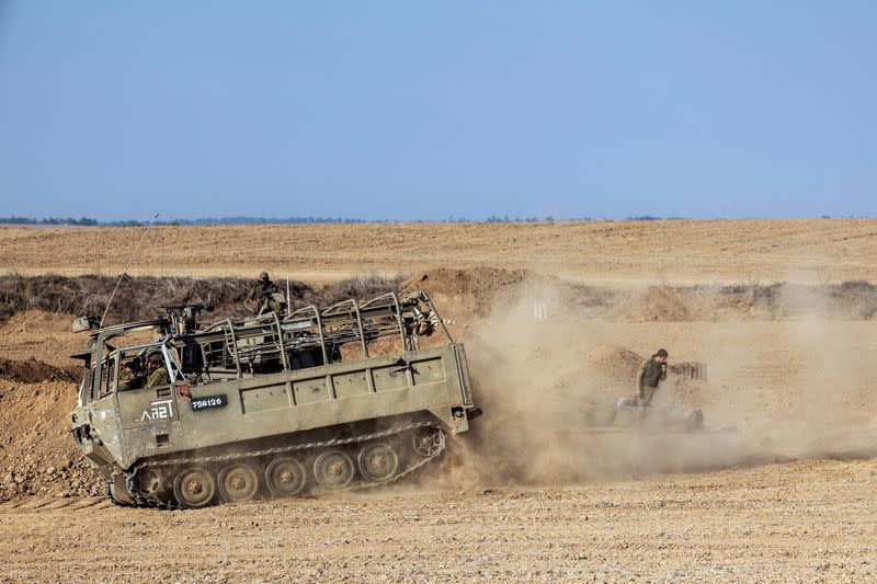 Israeli military vehicles and soldiers from an artillery unit gather near Israel's border with the Gaza Strip, in southern Israel