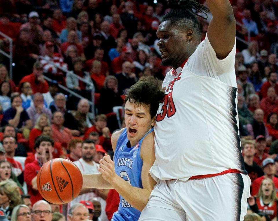 North Carolina’s Cormac Ryan drives past N.C. State’s DJ Burns Jr. during the first half of the Wolfpack’s game at PNC Arena on Wednesday, Jan. 10, 2024, in Raleigh, N.C.