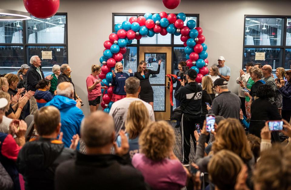 Wolverine Pickleball CEO and co-founder Christy Howden, center right, and co-founder Leslie White, center left, react to applause after doing a ribbon cutting ceremony for their privately owned business in Scio Township on Friday, December 1, 2023. The new, $7 million 39,000-square-foot indoor-outdoor facility will be the state's largest.