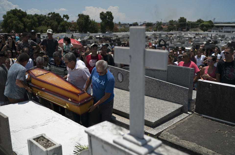 Fotografía del 17 de enero de 2019 de parientes y amigos cargando el féretro de Matheus Lessa, de 22 años, quien murió de un disparo cuando intentó defender a su madre durante un asalto en la tienda familiar en Río de Janeiro, Brasil. (AP Foto/Leo Correa)