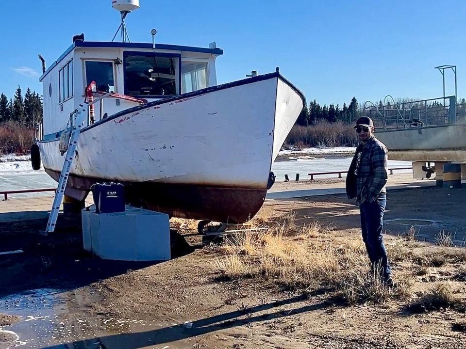 Campbell in front of his primary fishing boat, he received help from the Department of Industry, Tourism and Investments to purchase the boat.